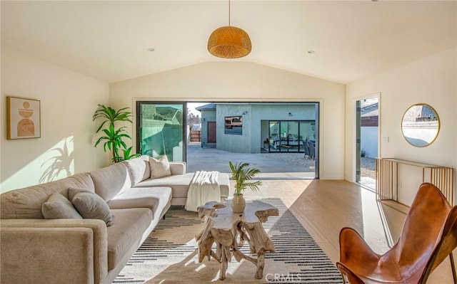 living room featuring lofted ceiling and light hardwood / wood-style floors