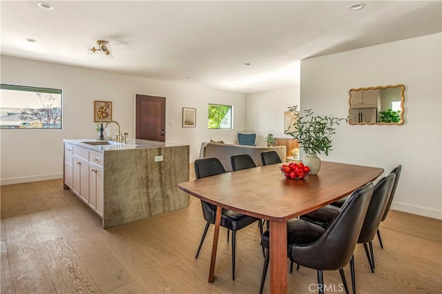 dining room with sink and light wood-type flooring