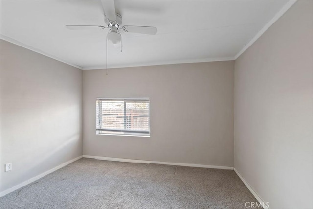 carpeted empty room with ceiling fan, baseboards, and crown molding