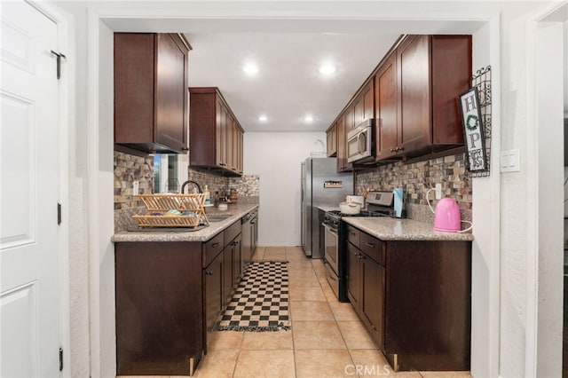 kitchen featuring tasteful backsplash, dark brown cabinetry, stainless steel appliances, and light tile patterned floors