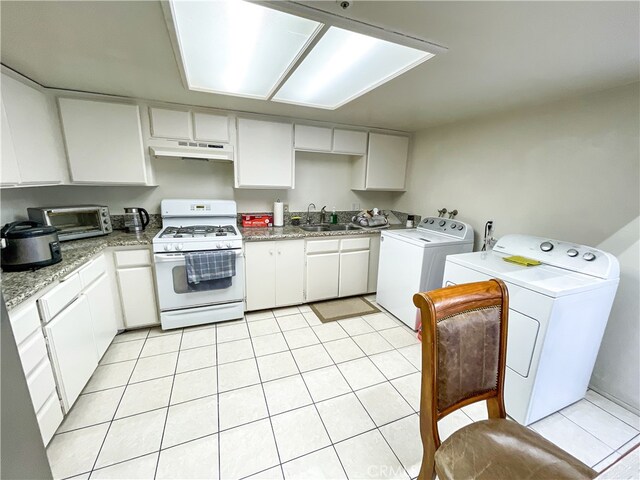 kitchen with sink, washer and clothes dryer, white cabinetry, light tile patterned flooring, and white gas range