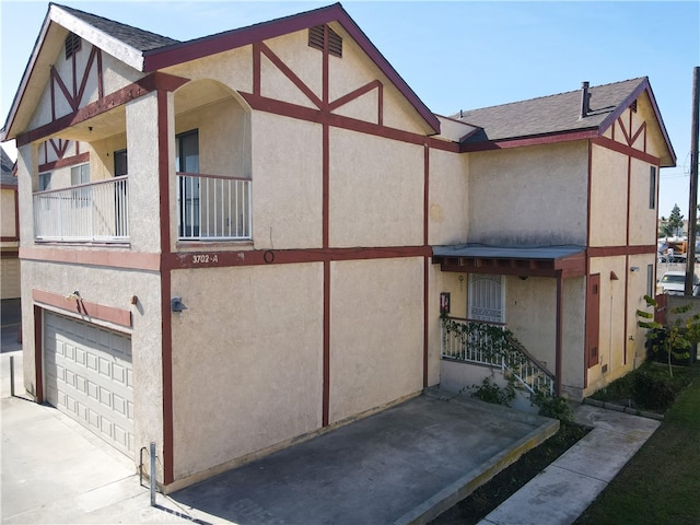 view of side of property with a balcony and a garage