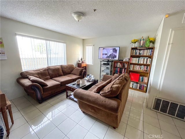 tiled living room featuring a textured ceiling