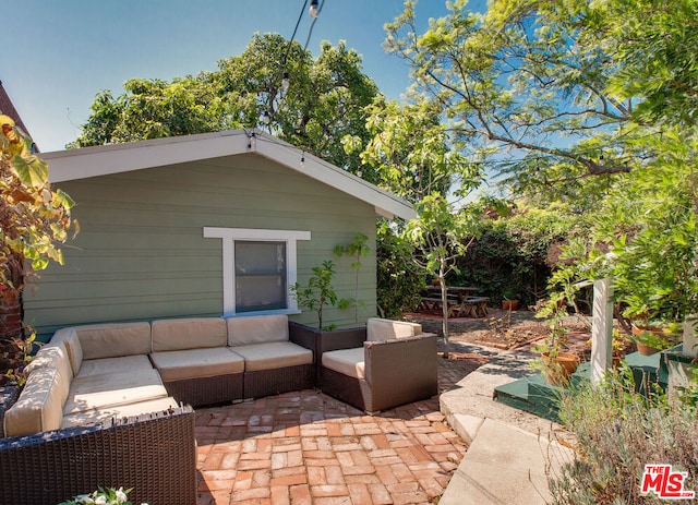 view of patio / terrace with an outdoor living space and an outbuilding