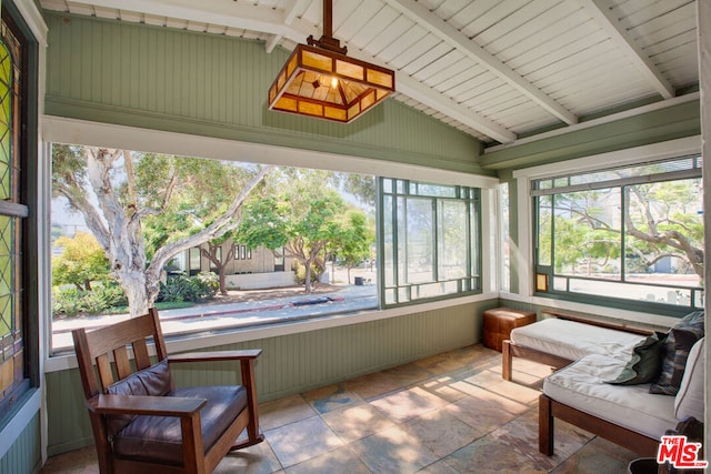 sunroom / solarium featuring plenty of natural light and lofted ceiling with beams