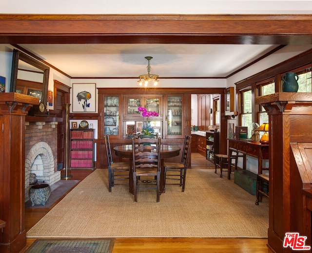 dining area with hardwood / wood-style flooring, a fireplace, and a chandelier