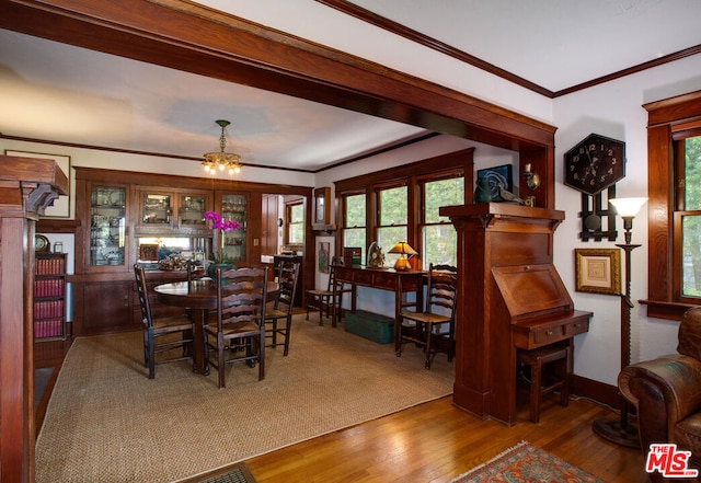 dining room featuring a notable chandelier, crown molding, and wood-type flooring