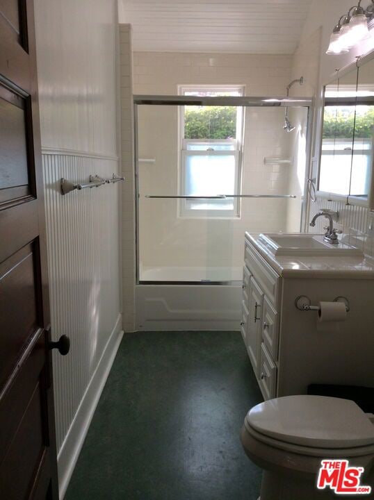 full bathroom featuring enclosed tub / shower combo, vanity, and toilet