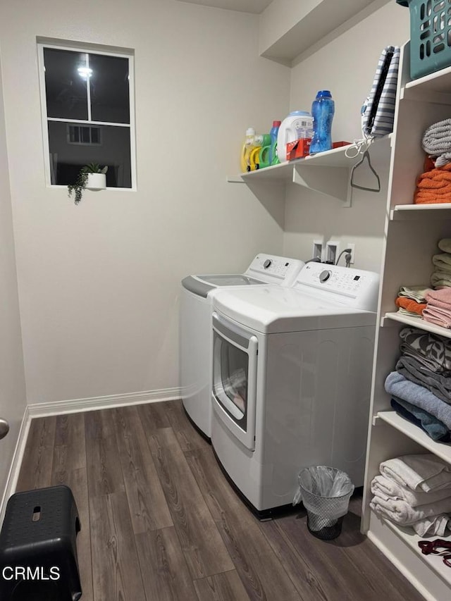 washroom featuring dark wood-type flooring and washer and clothes dryer