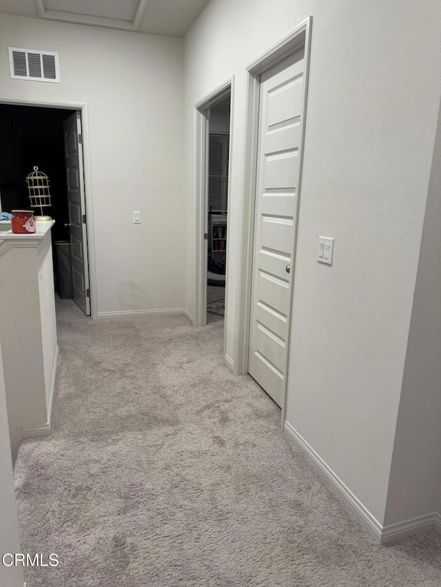 hallway featuring light colored carpet