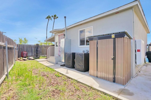 back of house with a lawn and a storage shed