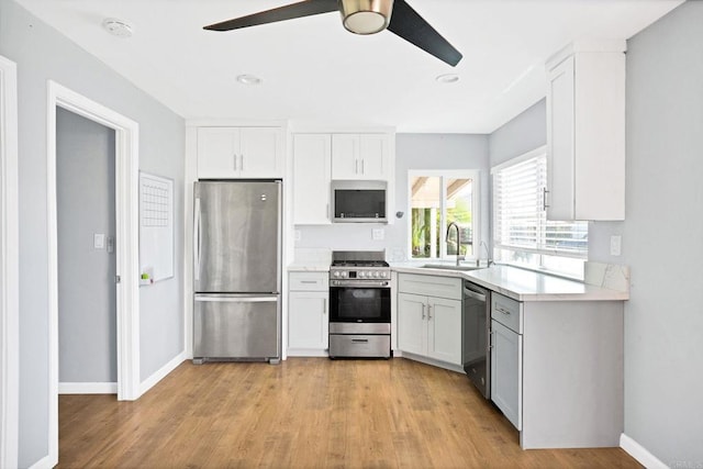 kitchen with white cabinetry, ceiling fan, appliances with stainless steel finishes, and sink