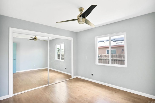 unfurnished bedroom with hardwood / wood-style flooring, ceiling fan, and a closet