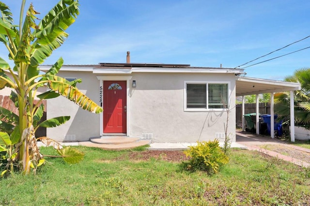 view of front of house with a carport and a front lawn