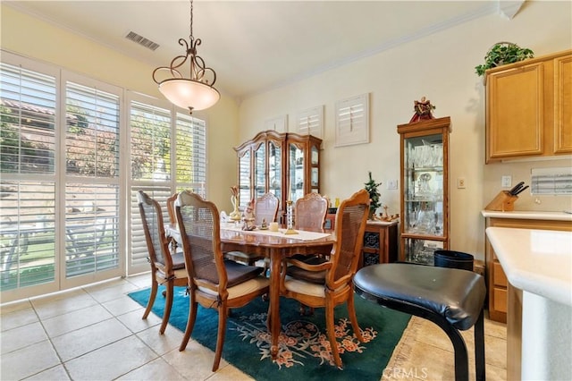 dining area featuring light tile patterned floors and ornamental molding