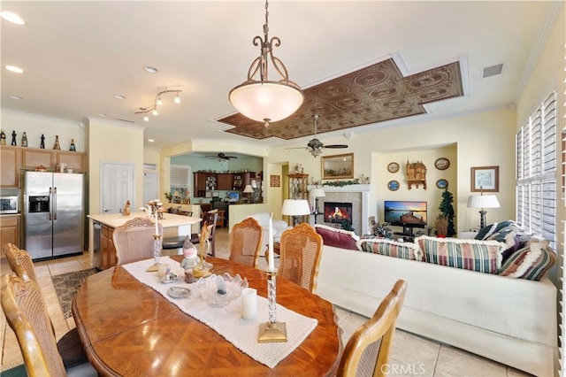 tiled dining room with crown molding and ceiling fan