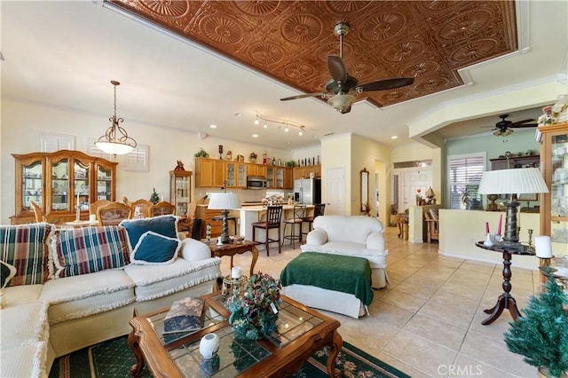 tiled living room with crown molding and ceiling fan