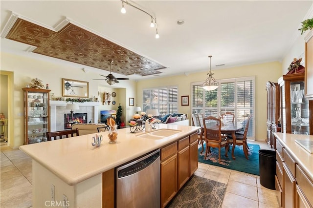 kitchen with sink, light tile patterned floors, an island with sink, decorative light fixtures, and stainless steel dishwasher