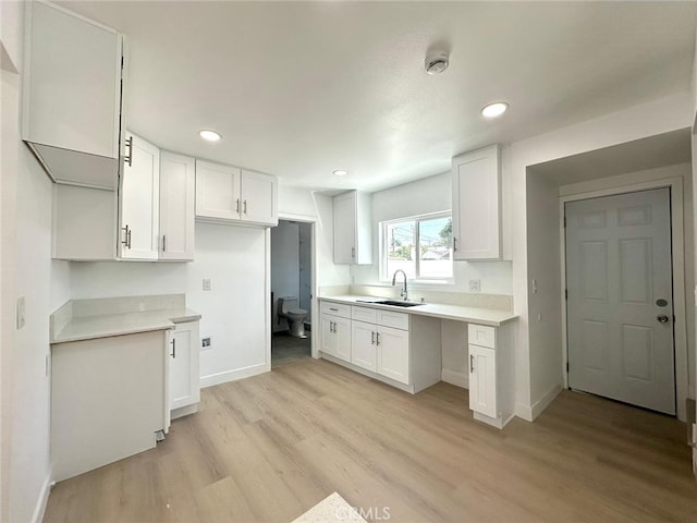 kitchen featuring sink, white cabinets, and light hardwood / wood-style flooring