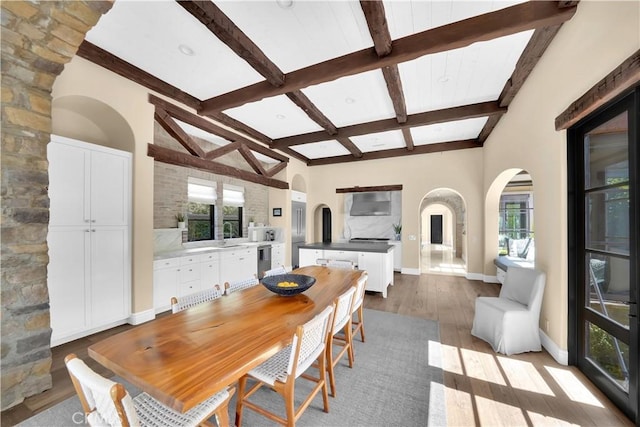 dining room with beamed ceiling, sink, and hardwood / wood-style floors