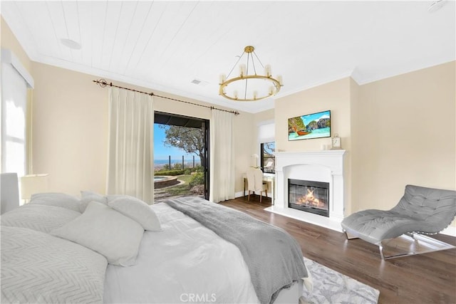 bedroom with access to outside, ornamental molding, dark hardwood / wood-style floors, and a chandelier