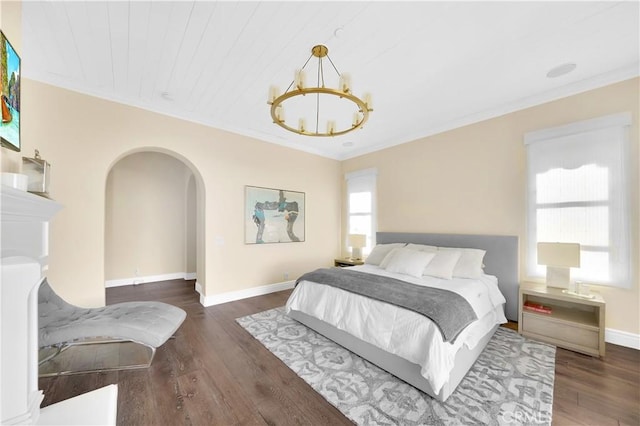 bedroom featuring crown molding, dark hardwood / wood-style floors, and a chandelier