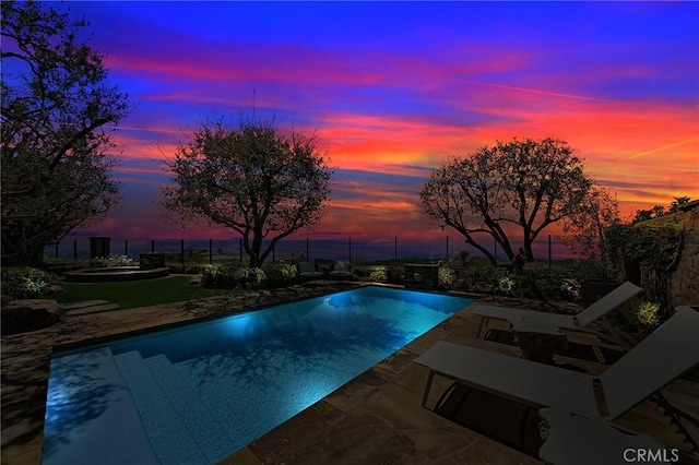 pool at dusk with a patio