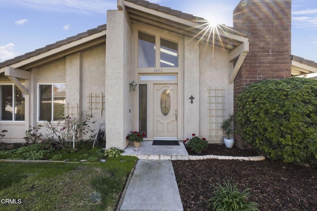 doorway to property featuring stucco siding