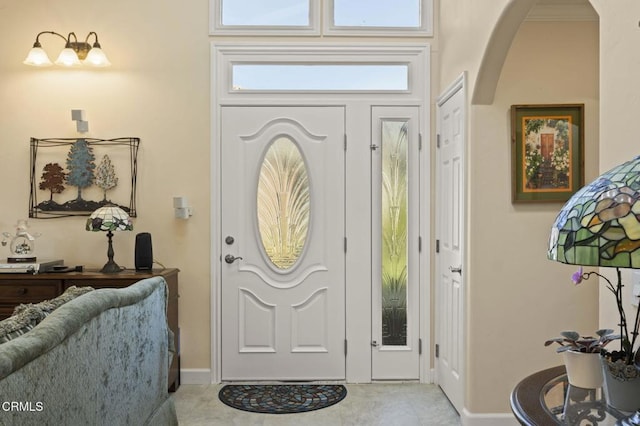 entrance foyer featuring arched walkways and light tile patterned floors