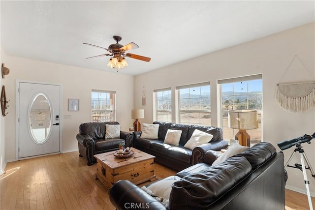 living room with ceiling fan, plenty of natural light, and light hardwood / wood-style floors