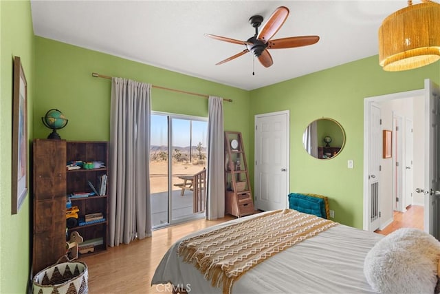 bedroom with access to exterior, light hardwood / wood-style floors, and ceiling fan