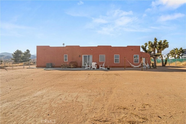 rear view of property with a mountain view, central AC unit, and a patio area