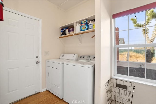 clothes washing area featuring light hardwood / wood-style floors and washer and dryer