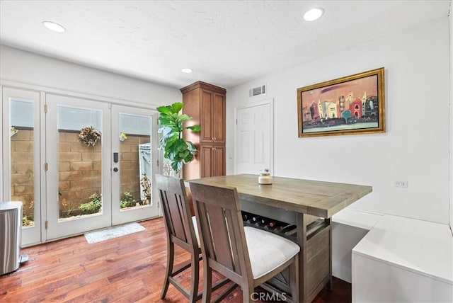 dining area with french doors and light hardwood / wood-style flooring