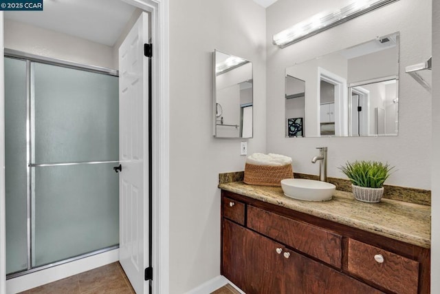 bathroom featuring vanity, an enclosed shower, and tile patterned flooring