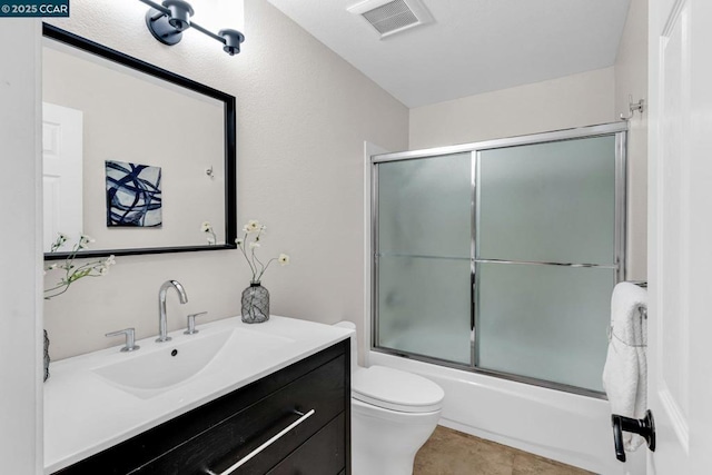 full bathroom featuring vanity, combined bath / shower with glass door, and toilet