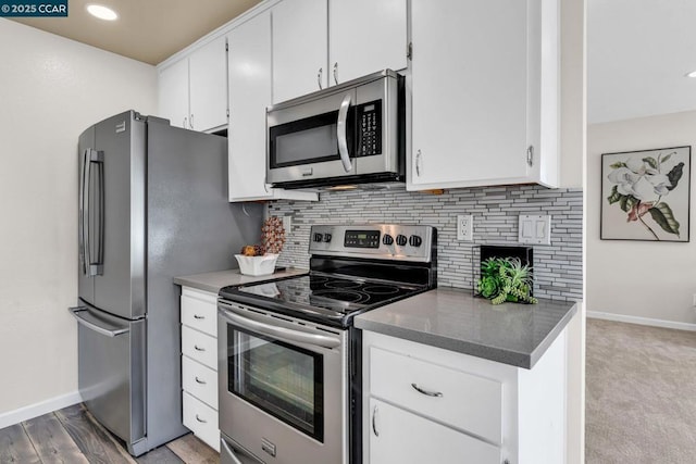 kitchen featuring decorative backsplash, light hardwood / wood-style floors, white cabinets, and appliances with stainless steel finishes