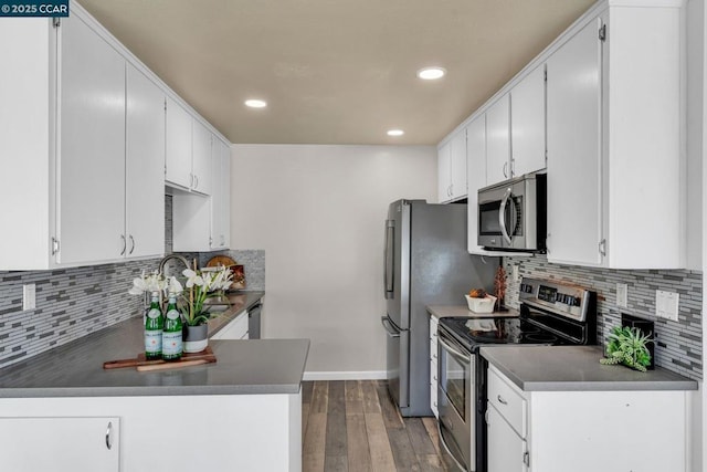 kitchen with appliances with stainless steel finishes, dark hardwood / wood-style floors, and white cabinets