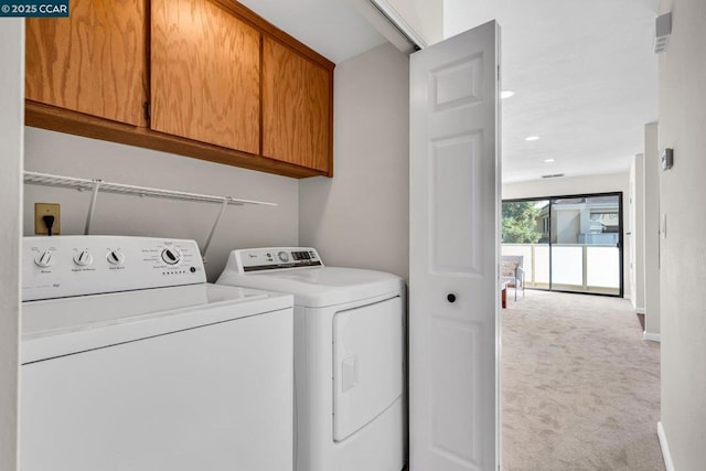 laundry room featuring light colored carpet, cabinets, and washing machine and clothes dryer