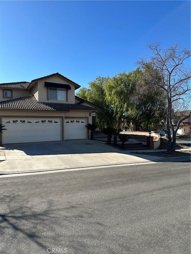 1310 Parsley Ln, Corona, CA 92879 - view of front of home with stucco siding, driveway, an attached garage, and a tiled roof