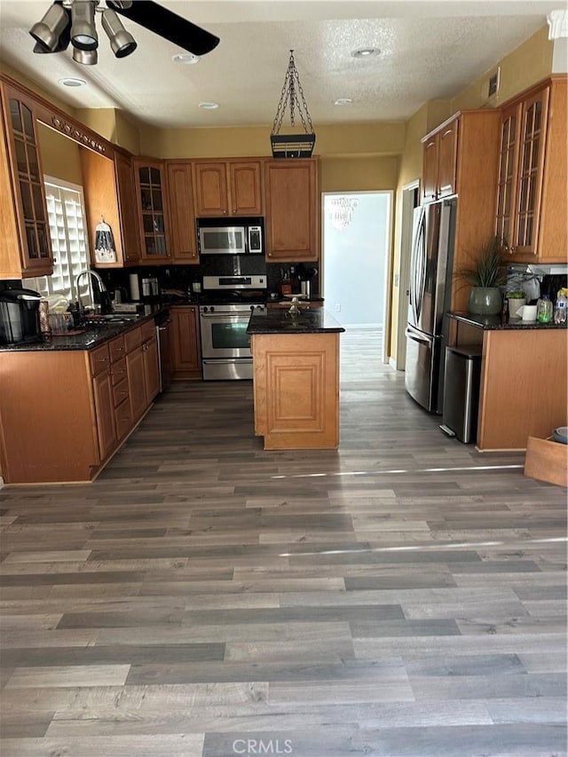 kitchen with sink, a textured ceiling, appliances with stainless steel finishes, dark hardwood / wood-style flooring, and ceiling fan