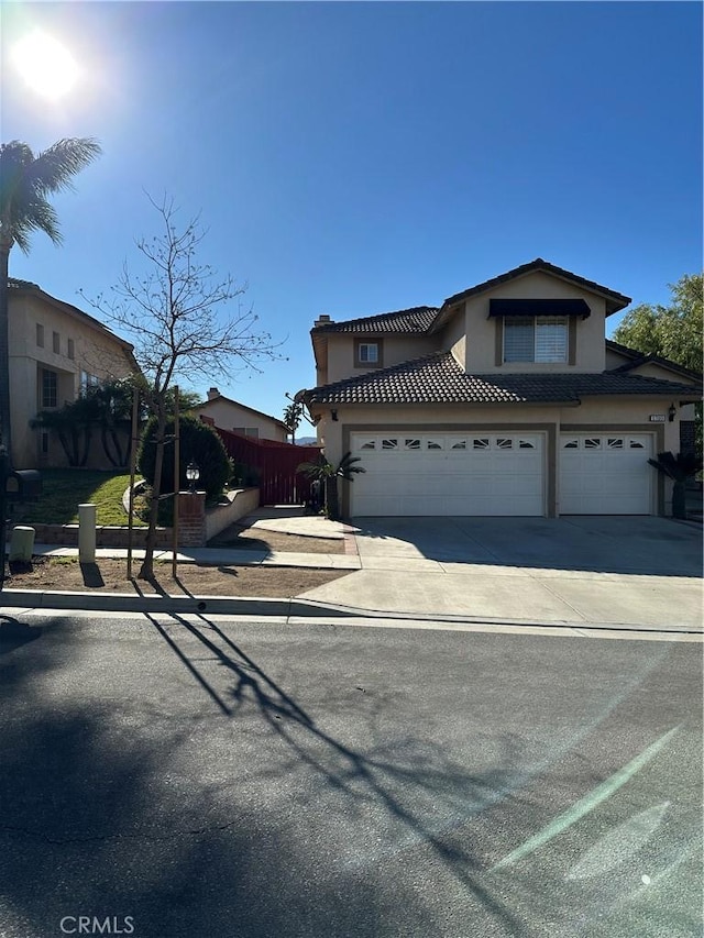 view of front of house featuring driveway, fence, and stucco siding