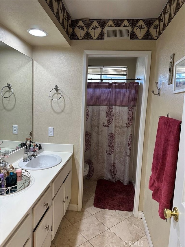 bathroom featuring a shower with curtain, vanity, tile patterned floors, and toilet