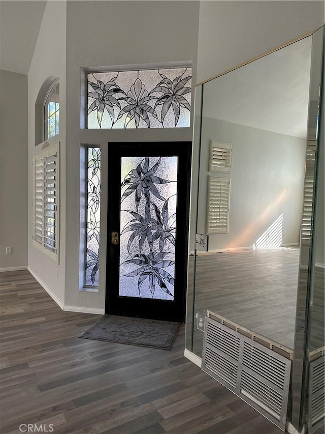 entrance foyer featuring dark hardwood / wood-style flooring and lofted ceiling