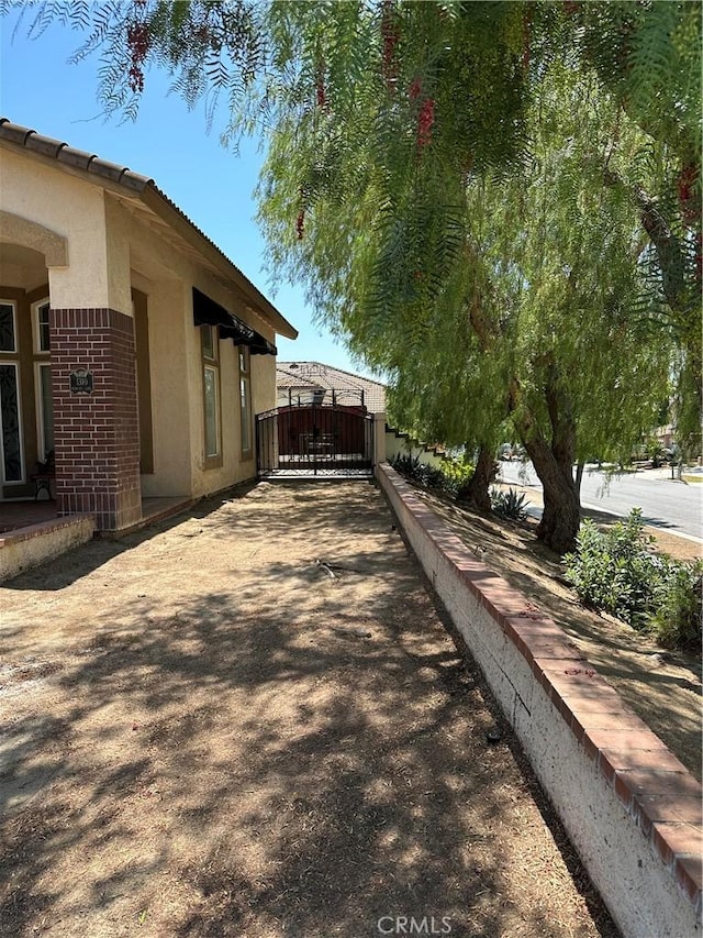 1310 Parsley Ln, Corona, CA 92879 - view of home's exterior with brick siding, a gate, and stucco siding