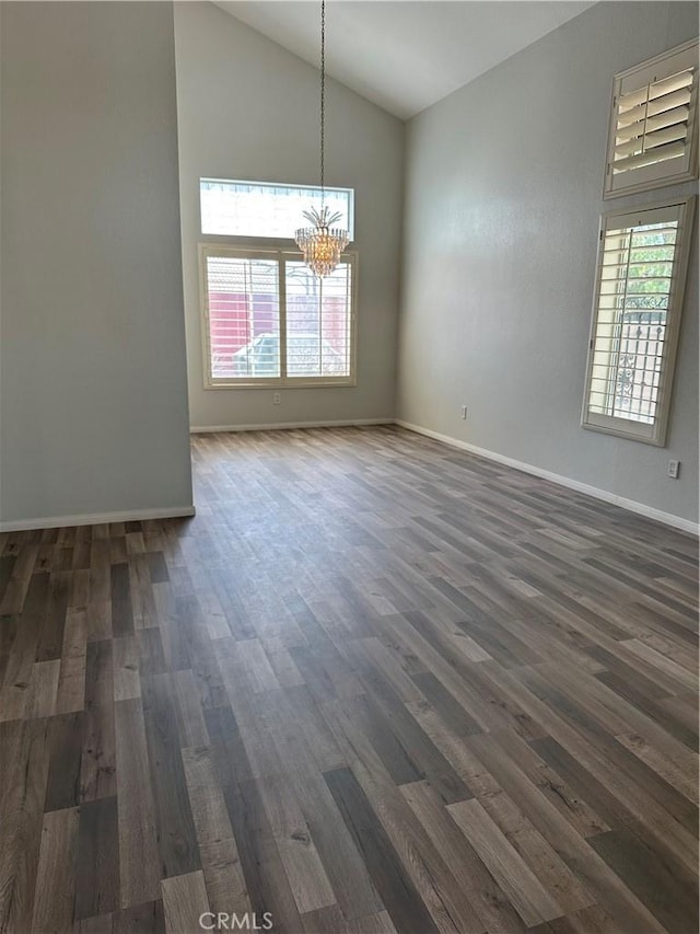 1310 Parsley Ln, Corona, CA 92879 - empty room with a chandelier, lofted ceiling, plenty of natural light, and dark wood finished floors