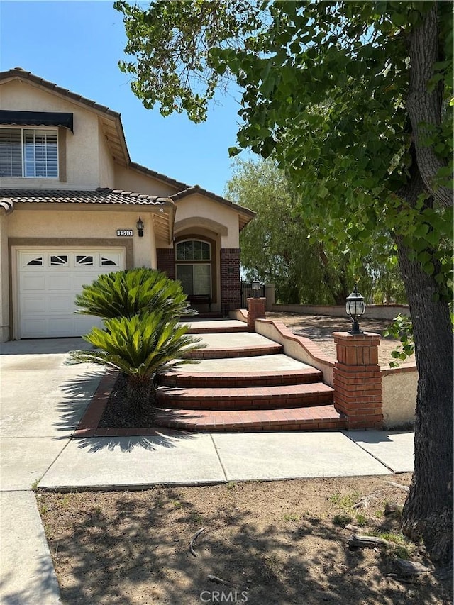 1310 Parsley Ln, Corona, CA 92879 - view of front of home featuring driveway, a tiled roof, stucco siding, and a garage