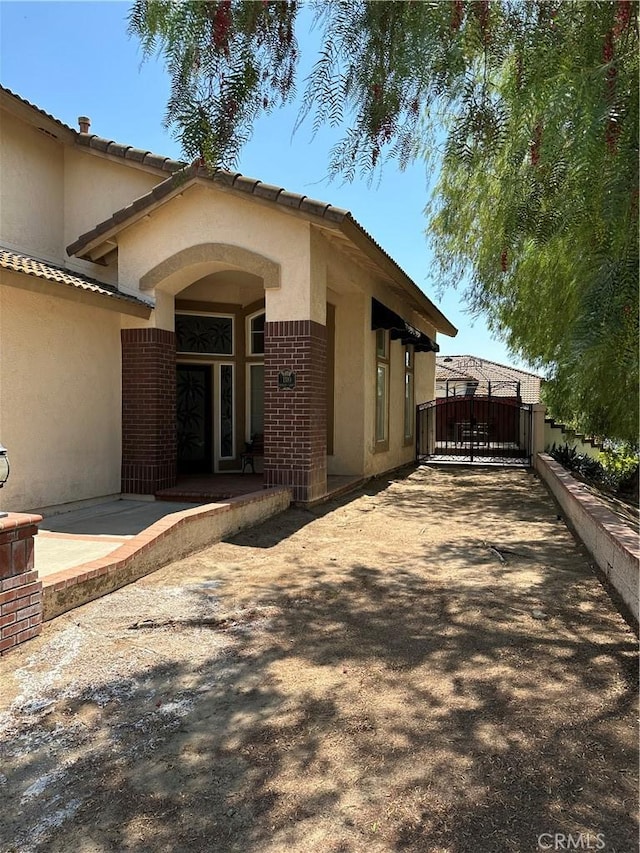 1310 Parsley Ln, Corona, CA 92879 - entrance to property featuring brick siding, stucco siding, and a gate