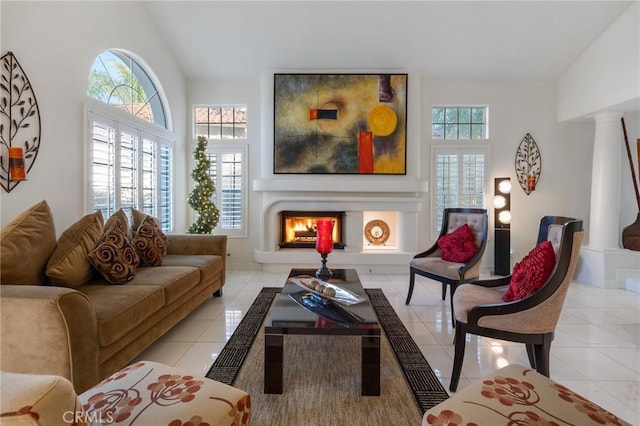 living area featuring decorative columns and light tile patterned floors