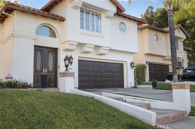 mediterranean / spanish-style home featuring a garage and a front yard